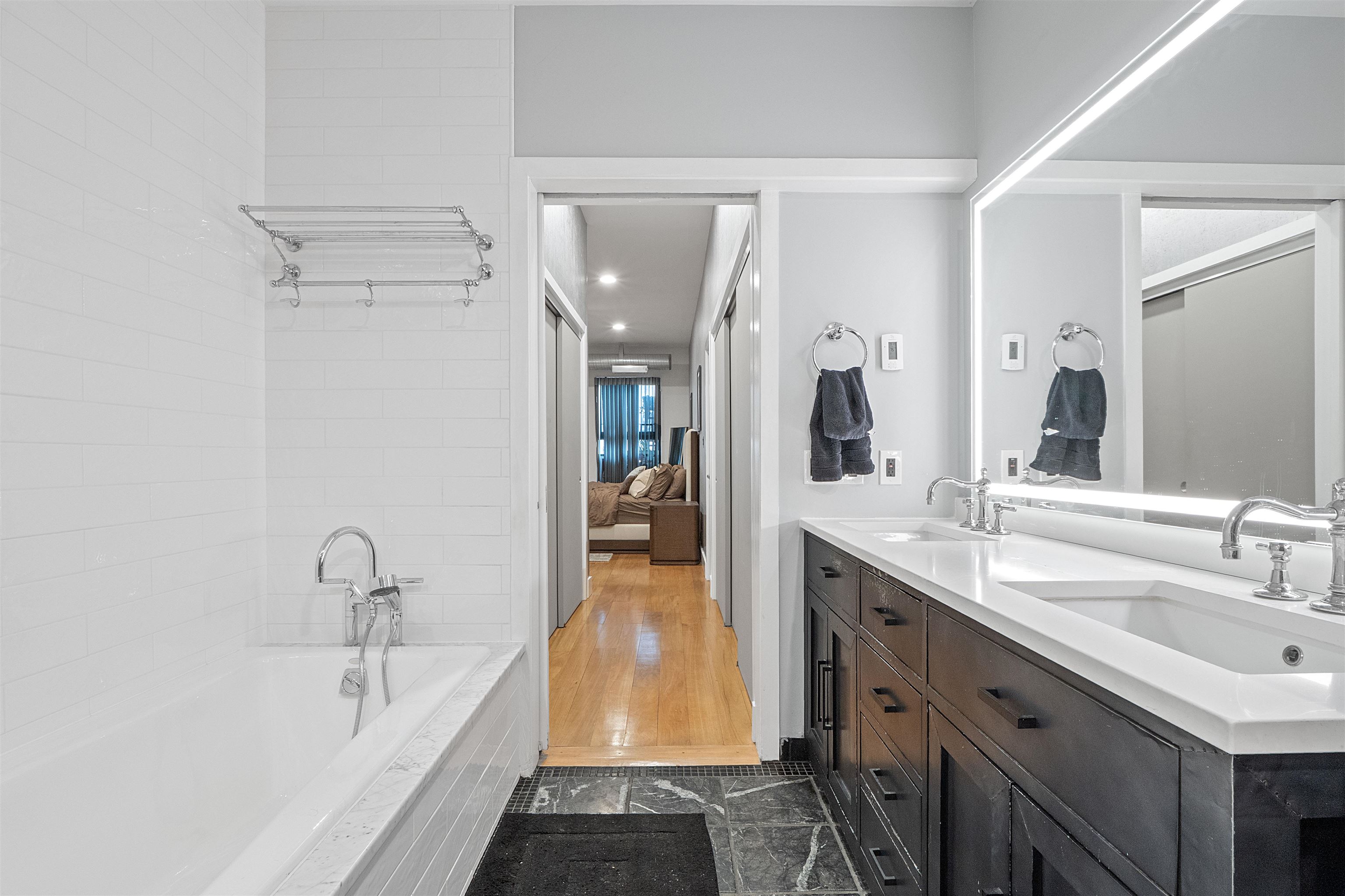 610 Clinton Street, Unit 2A Hoboken, NJ 07030 - Photo 30 of 33 a spacious bathroom with a granite countertop sink and a mirror