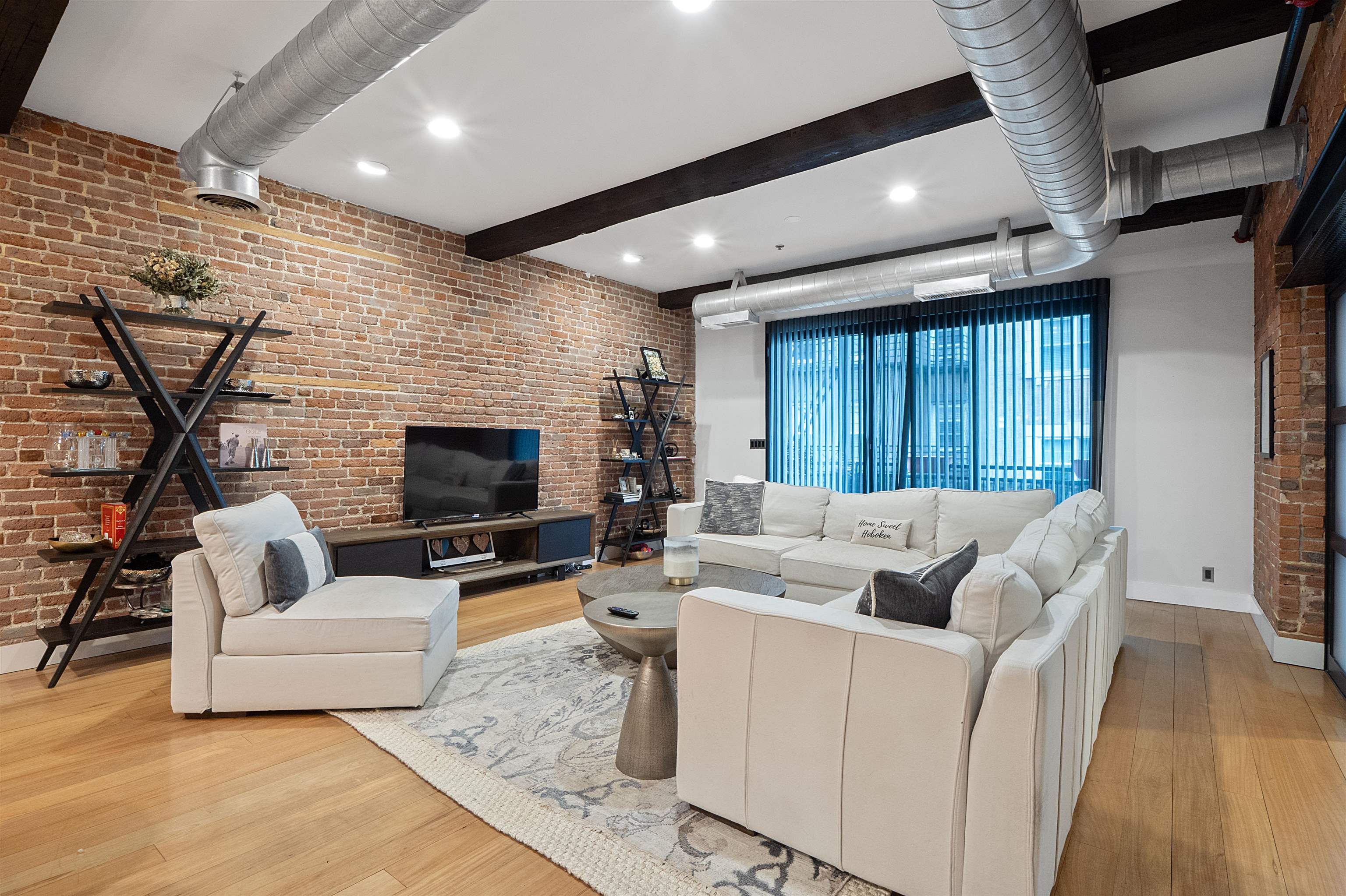 610 Clinton Street, Unit 2A Hoboken, NJ 07030 - Photo 6 of 33 a living room with furniture a fireplace and a flat screen tv