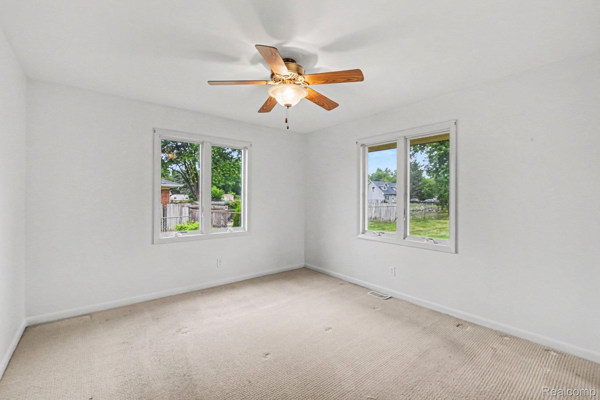 5199 Lapeer Road Burton, MI 48509 - Photo 10 of 19 Primary Bedroom. Neutral-toned carpeting extends throughout this room, complemented by a ceiling fan with integrated lighting