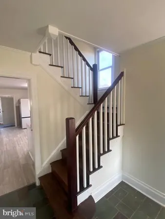 a view of an empty room with wooden floor fireplace and a window