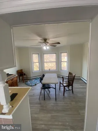 a large white kitchen with stainless steel appliances granite countertop a stove a sink dishwasher and white cabinets with wooden floor