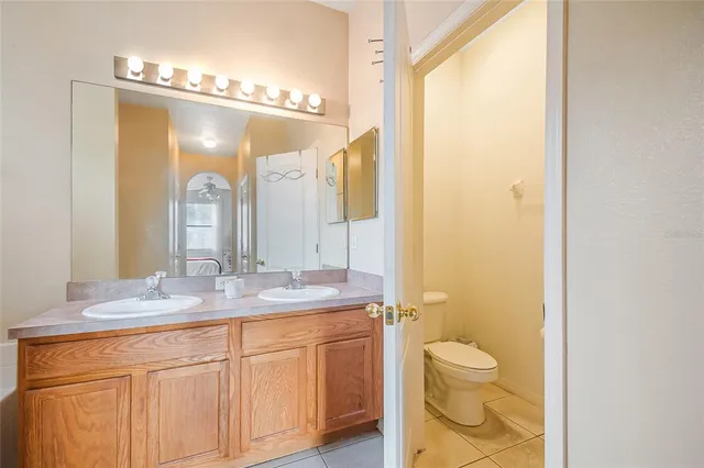a bathroom with a granite countertop sink a mirror a bathtub and shower