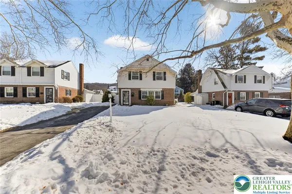a view of residential houses with snow on the road