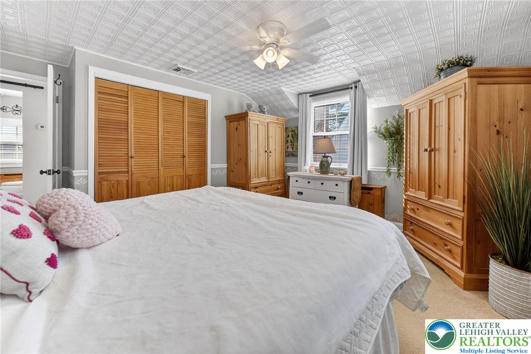 926 Buttonwood Street Emmaus, PA 18049 - Photo 22 of 63 a bedroom with a large bed and a chandelier
