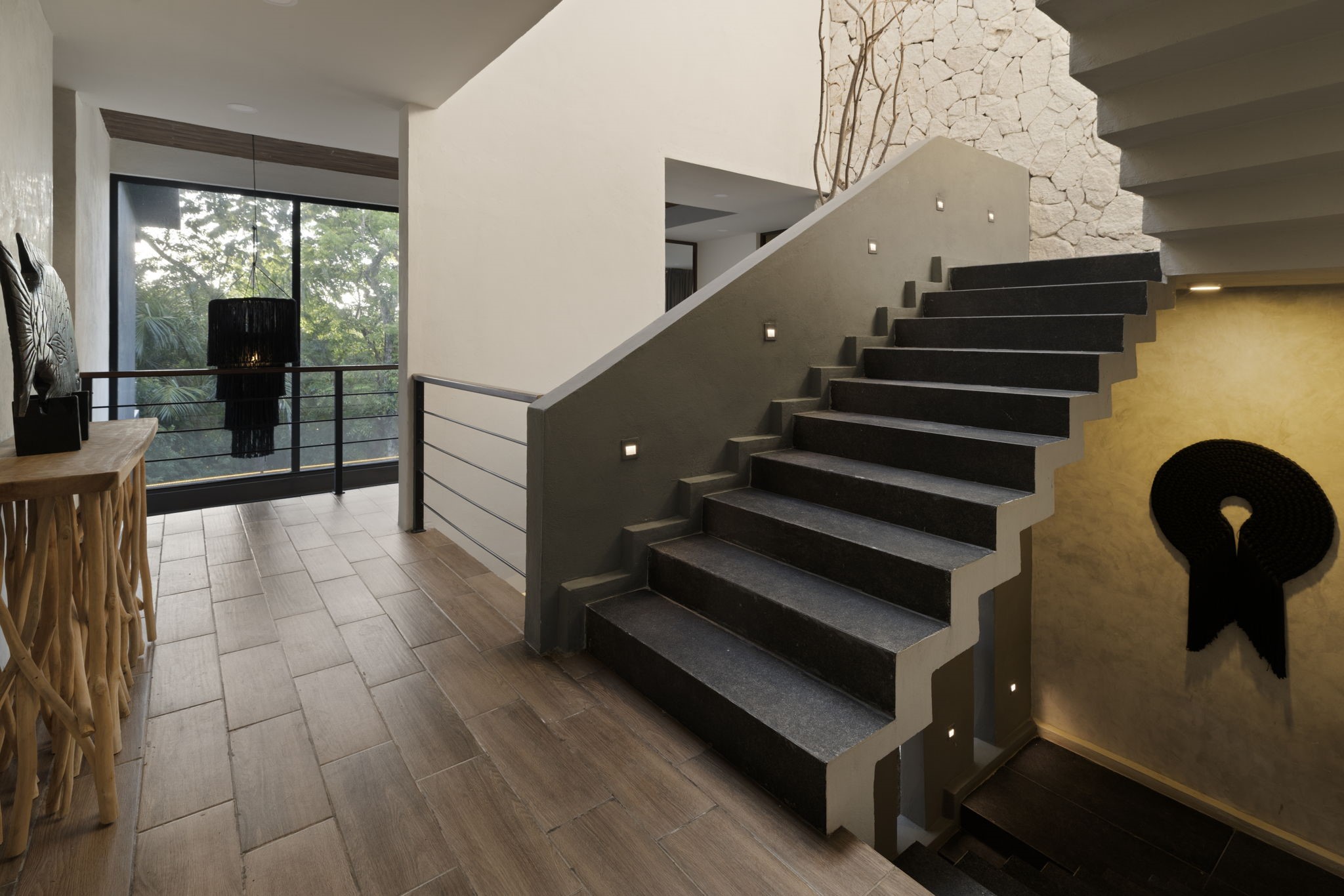 6 Country Club, Unit 4 Nome, TX 77629 - Photo 18 of 45 This dramatic architectural staircase serves as a stunning sculptural centerpiece, anchoring the home's multi-level circulation with bold geometric design and rich organic accents.