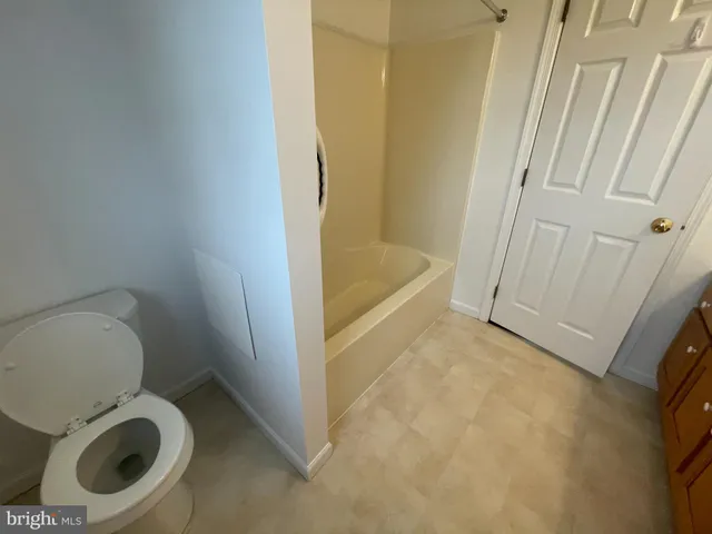 a bathroom with a toilet and a tub