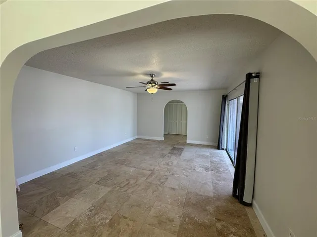 a view of a livingroom with a ceiling fan and window