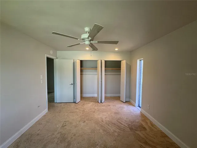 an empty room with closet and windows