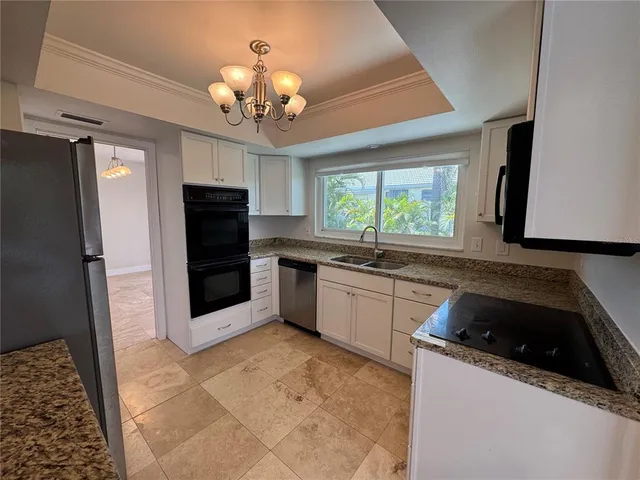 a kitchen with stainless steel appliances granite countertop a sink and a refrigerator