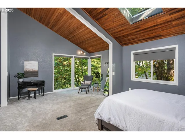 a bed sitting in a spacious bedroom next to a window