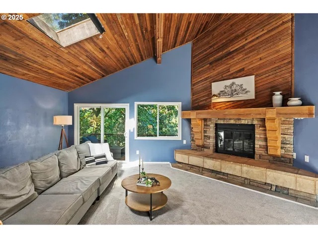 a living room with furniture a fireplace and a large window