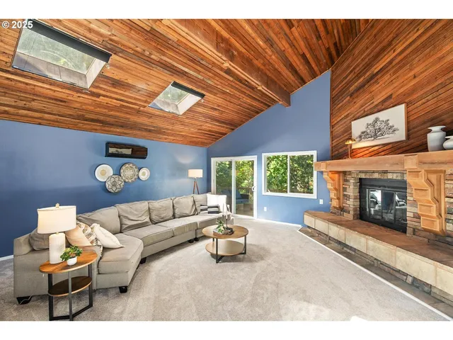 a living room with furniture a fireplace and a large window