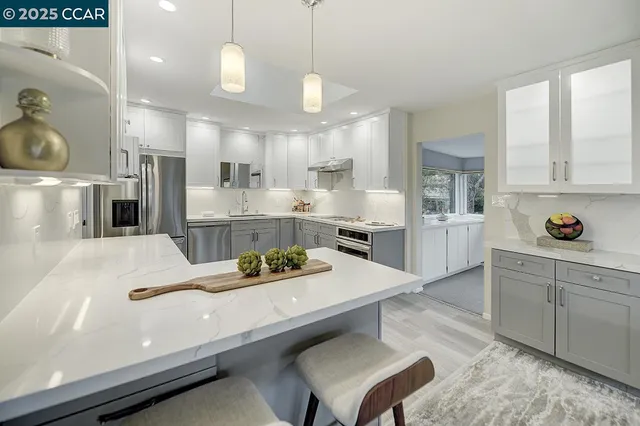 a kitchen with kitchen island white cabinets and refrigerator