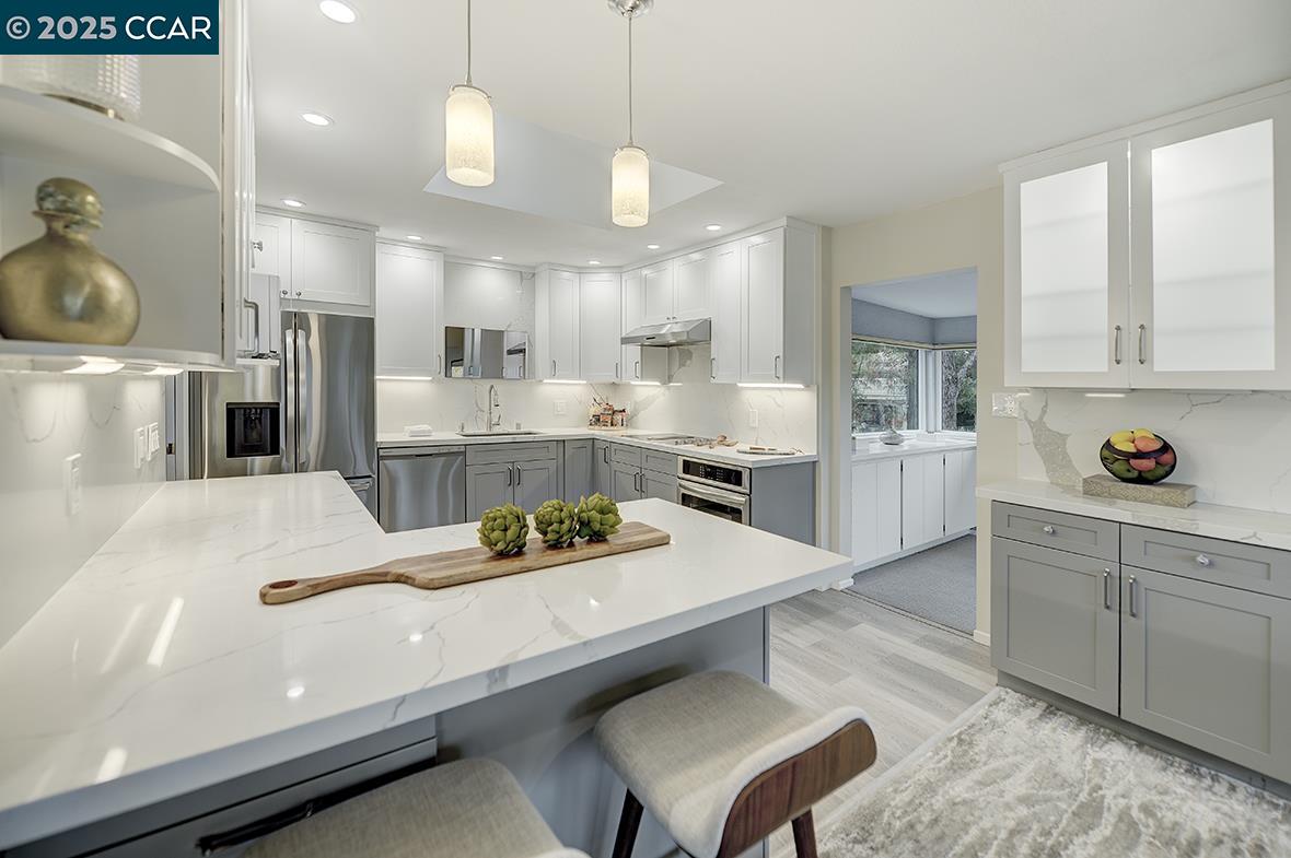a kitchen with kitchen island white cabinets and refrigerator