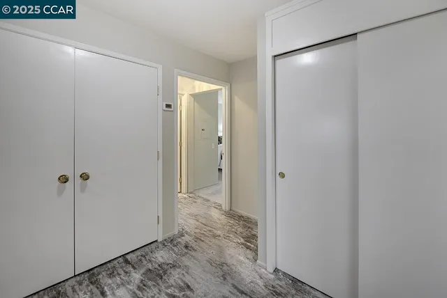 a bedroom with a bed and large windows