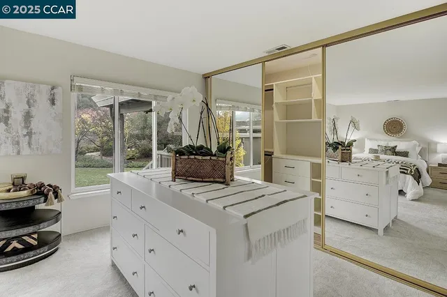 a spacious bedroom with a bed a table and large window