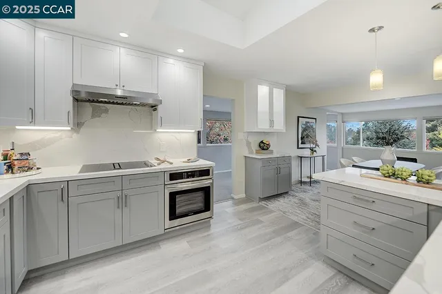 a kitchen with stainless steel appliances granite countertop a stove a sink and a refrigerator