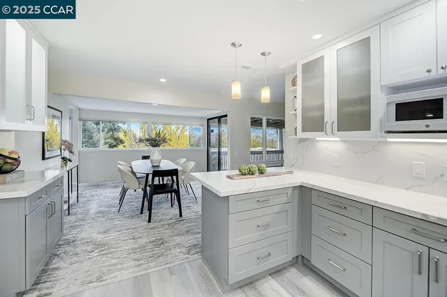 a kitchen with white cabinets and sink