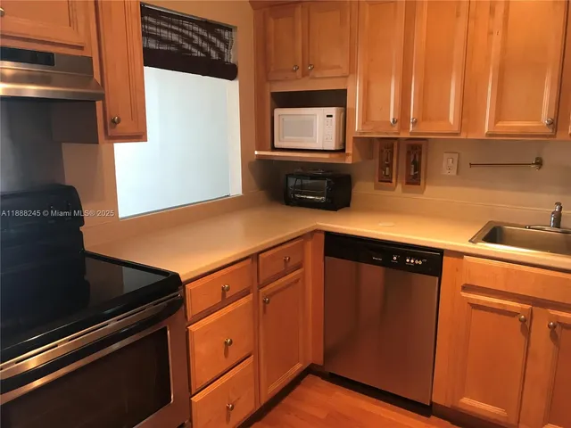a kitchen with granite countertop wooden cabinets and a stove