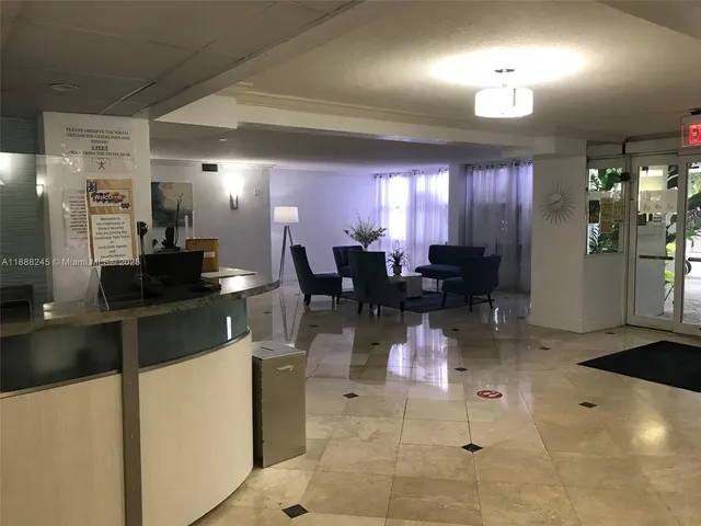 a kitchen with stainless steel appliances kitchen island granite countertop dining table chairs and a refrigerator