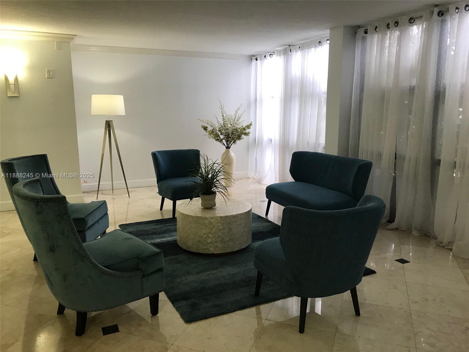 1000 Parkview Drive, Unit 627 Hallandale Beach, FL 33009 - Photo 23 of 27 a living room with furniture and a lamp