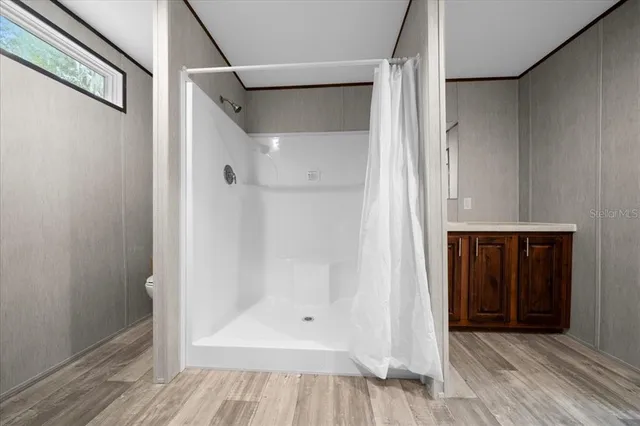 a view of walk in closet with wooden floor