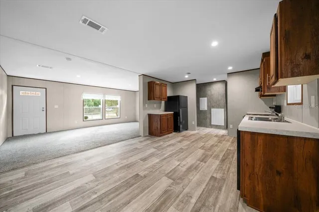 a large kitchen with kitchen island granite countertop a sink refrigerator and microwave