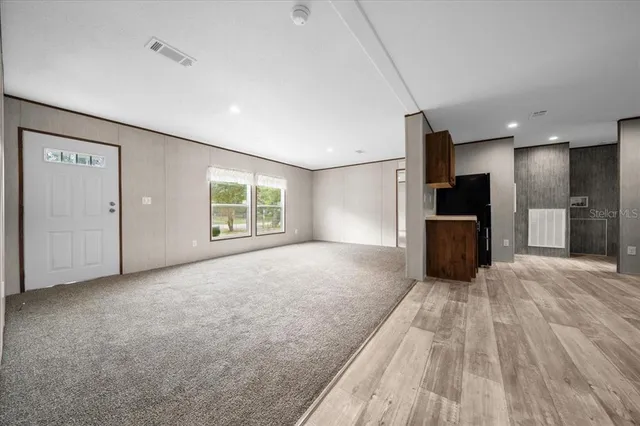 a view of empty room with wooden floor and windows