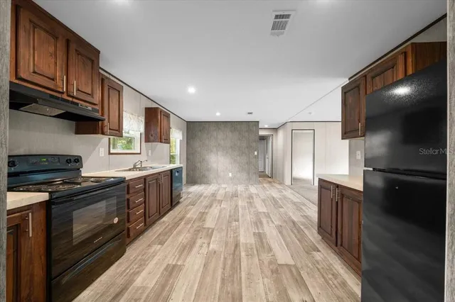 a kitchen with stainless steel appliances granite countertop a stove a sink and a refrigerator