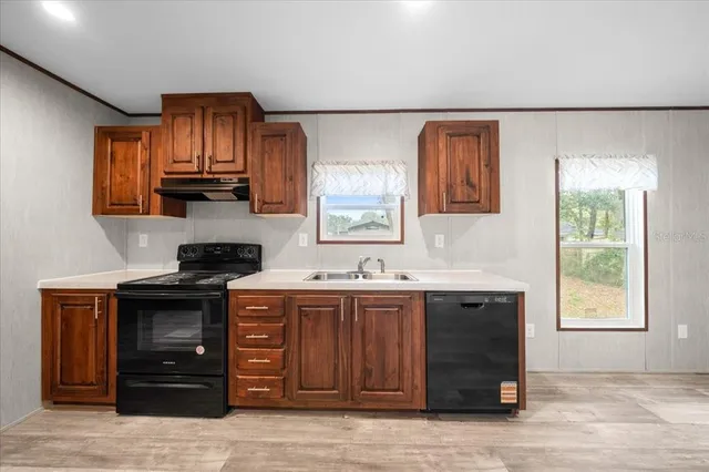 a kitchen with stainless steel appliances granite countertop wooden cabinets a sink and a stove