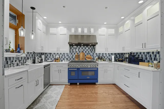a kitchen with stainless steel appliances granite countertop a stove and white cabinets