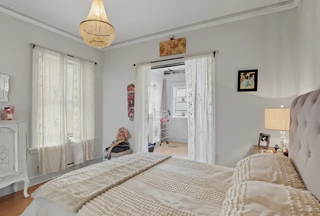 a bedroom with a bed and a chandelier