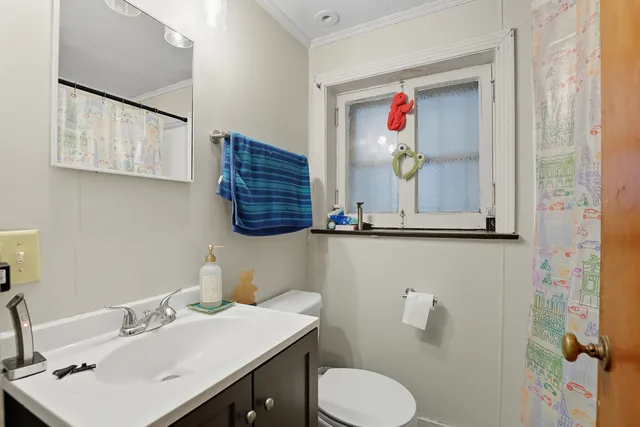 a bathroom with a sink vanity mirror and toilet