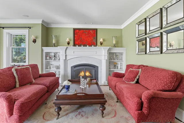 a living room with furniture fireplace and a window