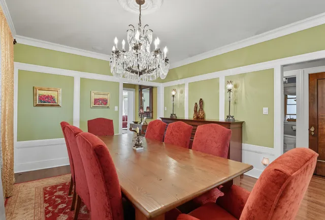 a view of a dining room with furniture a chandelier and wooden floor