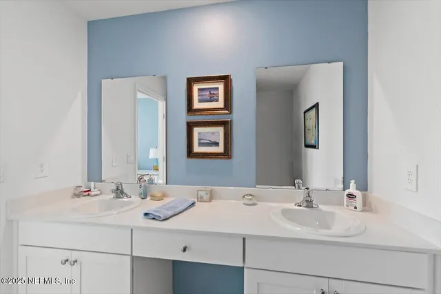 a bathroom with double sink and a mirror