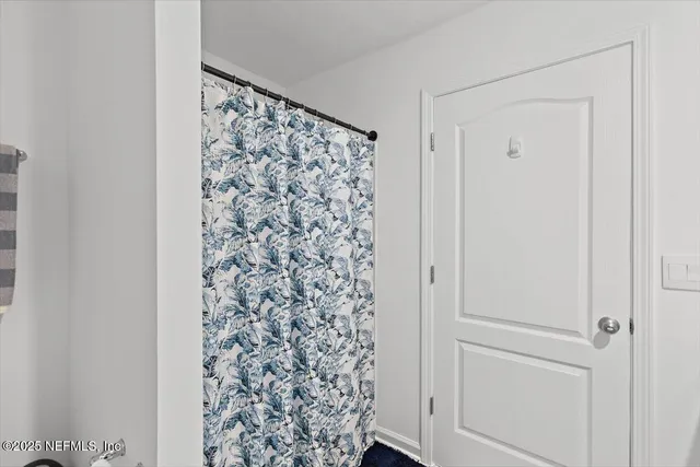 a view of bathroom with shower curtain