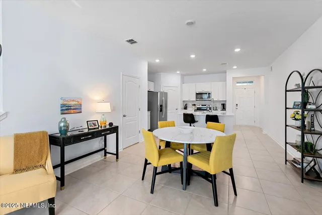 a living room with furniture and a dining table with kitchen view