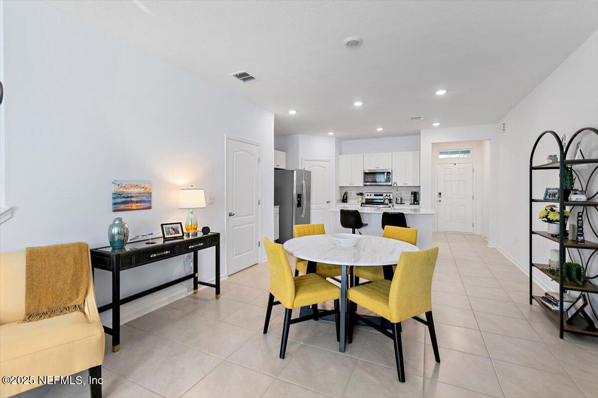 120 Seaport Breeze Rd Street St. Augustine, FL 32095 - Photo 7 of 25 a living room with furniture and a dining table with kitchen view