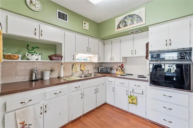 a kitchen with cabinets and wooden floor