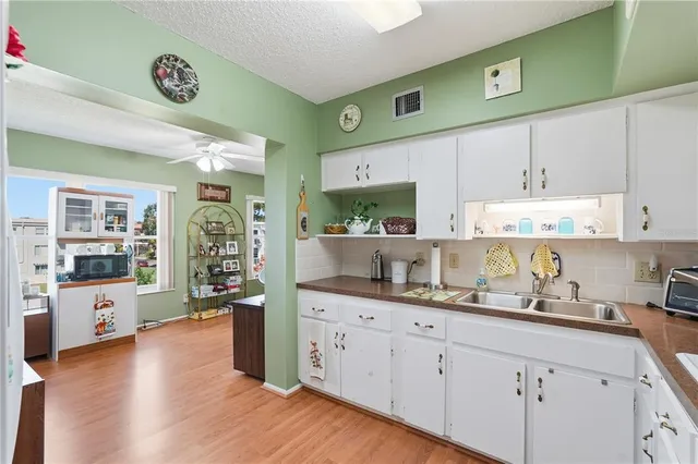 a kitchen with stainless steel appliances granite countertop a lot of counter space and wooden floors