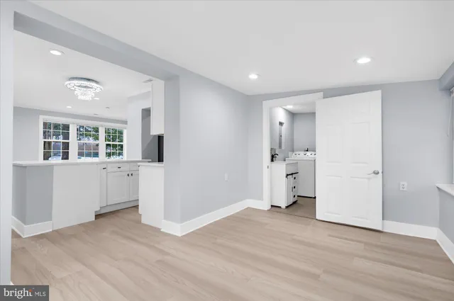 a view of empty room with wooden floor and windows