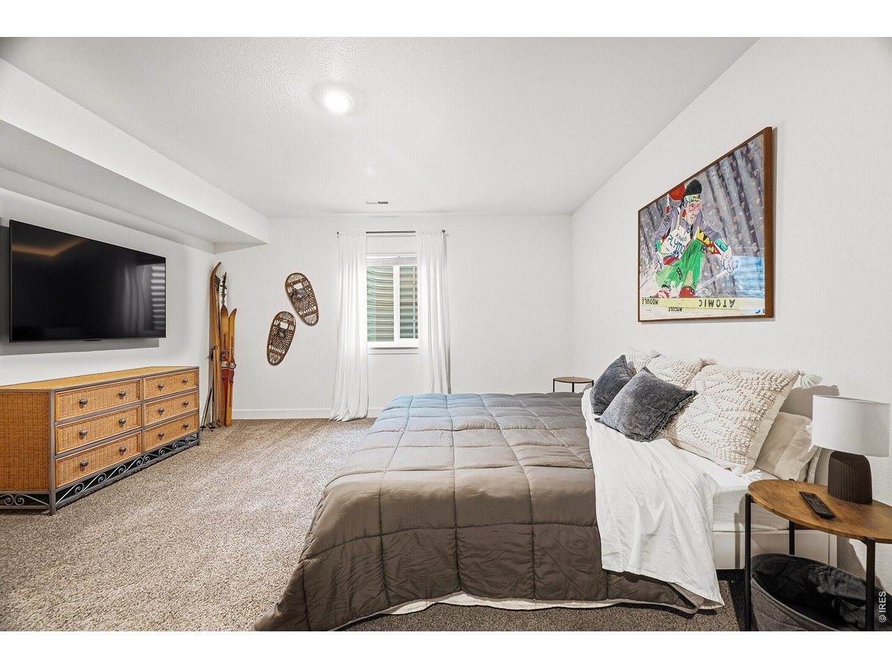 1699 Rivergate Way Berthoud, CO 80513 - Photo 24 of 45 a bedroom with a bed and a flat screen tv