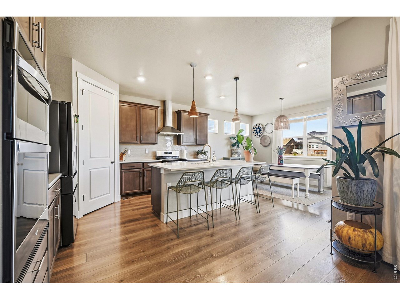 1699 Rivergate Way Berthoud, CO 80513 - Photo 8 of 45 a kitchen with stainless steel appliances a dining table chairs stove and cabinets