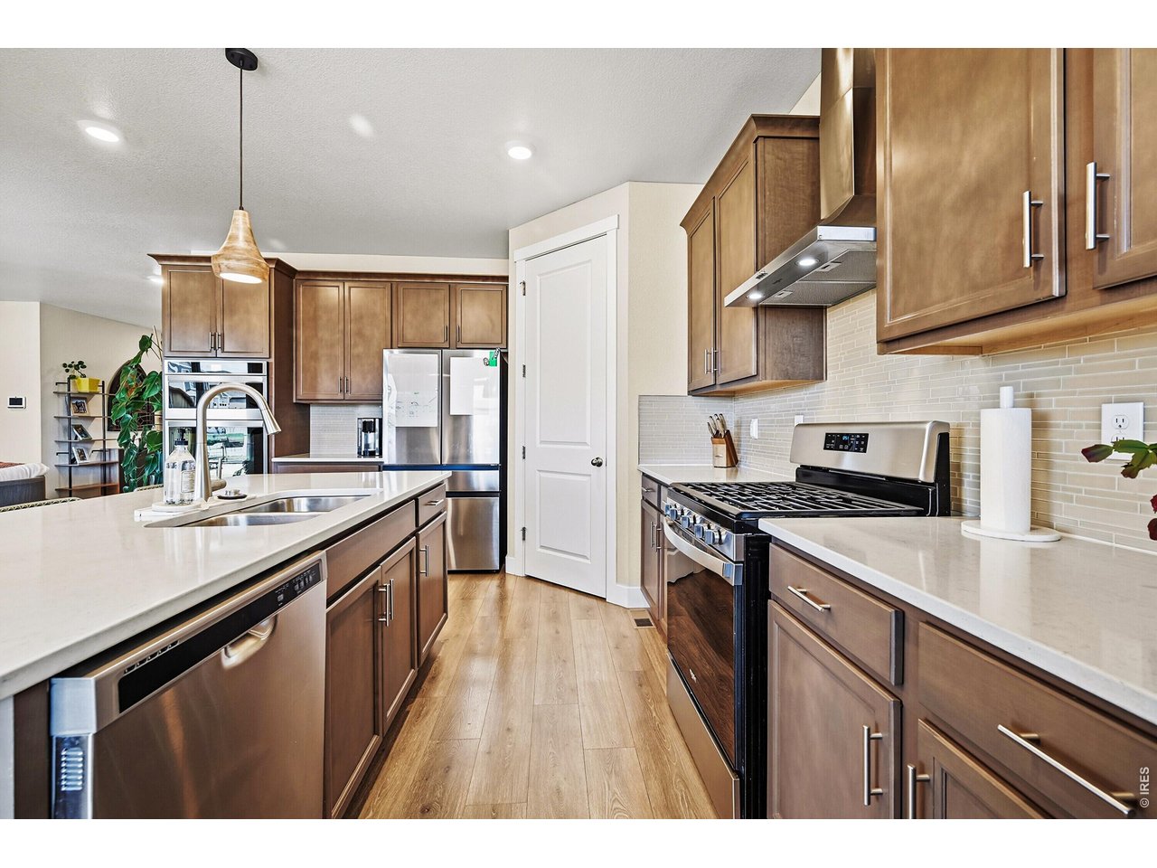 1699 Rivergate Way Berthoud, CO 80513 - Photo 10 of 45 a kitchen with stainless steel appliances granite countertop a sink a stove and a wooden floors