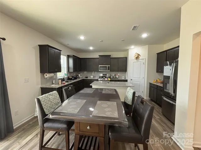 a large kitchen with a large window and stainless steel appliances