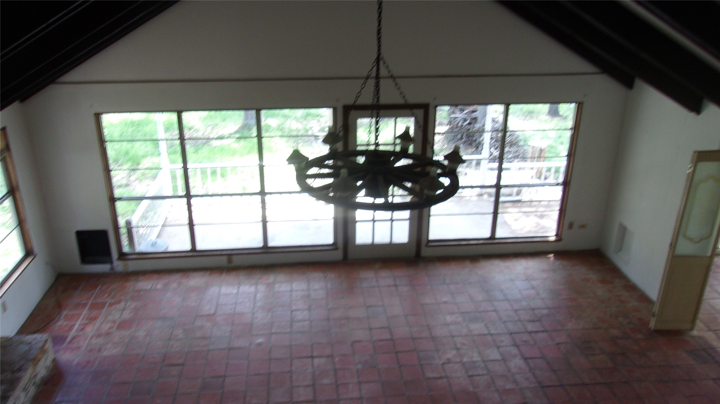702 Cottonwood Creek Road Dripping Springs, TX 78620 - Photo 16 of 31 Spacious room featuring vaulted ceilings with exposed dark beams, terracotta tile flooring, and a large rustic chandelier