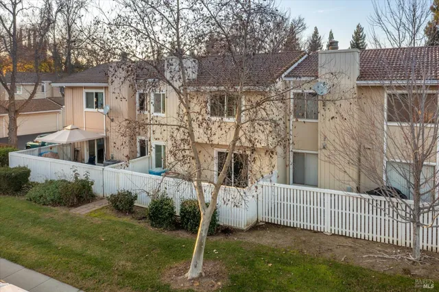 a front view of a house with a yard and large tree