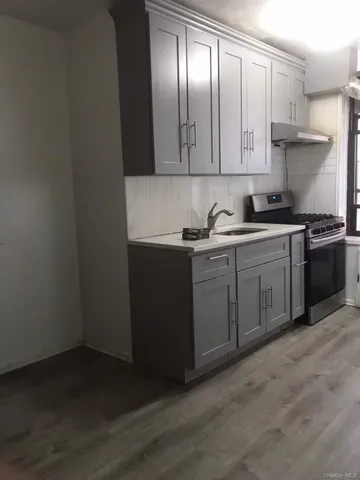 a kitchen with stainless steel appliances granite countertop a sink and cabinets with wooden floor