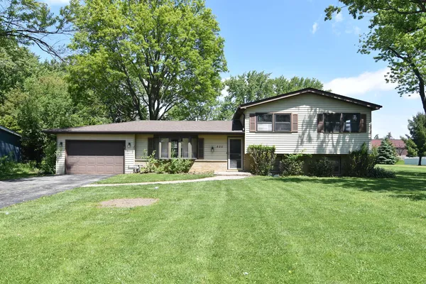 a view of a house with a yard and sitting area